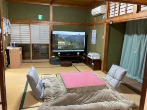 a living room with a tv and a couch and a table at 天水島ヒルズ in Tokamachi