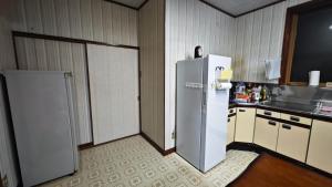 a kitchen with a refrigerator in the middle of a room at 天水島ヒルズ in Tokamachi