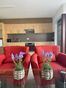 a living room with red chairs and a red couch at The Waves in Ostend