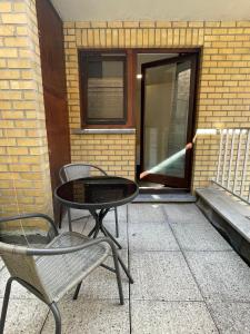 a patio with two chairs and a table and a door at The Waves in Ostend