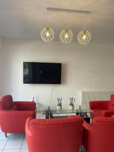 a living room with two red chairs and a table at The Waves in Ostend