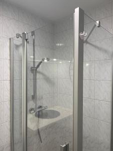 a shower with a glass door with a sink at The Waves in Ostend +9 photos