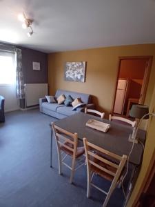 a living room with a table and a couch at Chez Lola in La-Roche-en-Ardenne