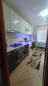a kitchen with white cabinets and a stove top oven at Apartament RHC in Târgu Ocna
