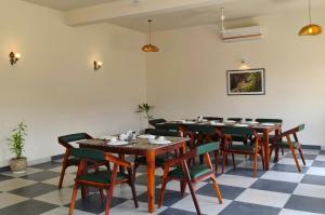 a dining room with tables and chairs and a checkered floor at Jawai-e-khaas in Bijāpur
