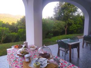 a table with plates of food on a patio at B&B Casa Corbezzolo in Procchio