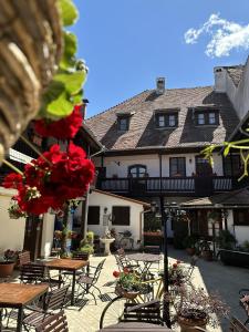 a courtyard with tables and chairs and a building at Hotel Casa Wagner in Sighişoara