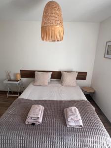 a bedroom with a bed with two towels on it at NeseHome, Maison à proximité du Futuroscope in Montamisé