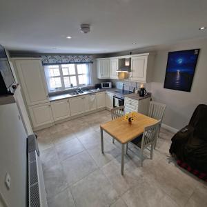 a kitchen with a wooden table and a dining room at Semos in Strabane