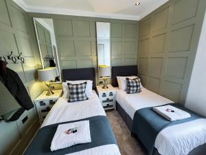 two beds in a room with two mirrors at 2 Bed Ground floor Apartment with parking in Auchterarder