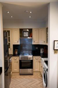 a kitchen with white cabinets and a stove top oven at 2 Bed Ground floor Apartment with parking in Auchterarder +15 photos