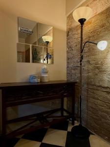 a room with a desk with a lamp and a stone wall at La Roccia in Reggio di Calabria +20 photos