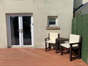 a patio with two chairs and a table and a door at 2 Bed Ground floor Apartment with parking in Auchterarder