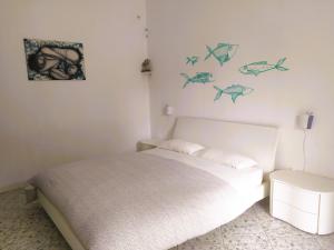 a bedroom with a bed with fish on the wall at B&B Casa Corbezzolo in Procchio
