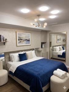 a bedroom with a large bed with blue sheets at Moldavian Luxury in Chişinău