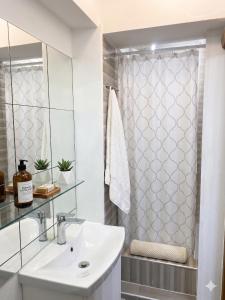 a white bathroom with a sink and a shower at Moldavian Luxury in Chişinău