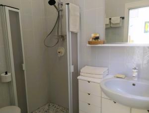a white bathroom with a shower and a sink at B&B Casa Corbezzolo in Procchio +21 photos