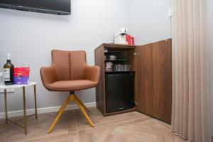 a brown chair in a room with a small refrigerator at Luxury Rooms by Iva in Zadar