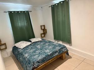 a bedroom with green curtains and a bed in it at Kay Yvette in Saint-Pierre