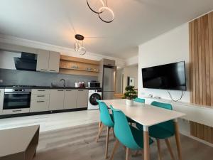 a kitchen and dining room with a table and chairs at DOCA Apartments 10 in Otopeni
