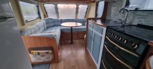 a kitchen with a couch and a table in a van at Peaceful Private Haven in Frongoch