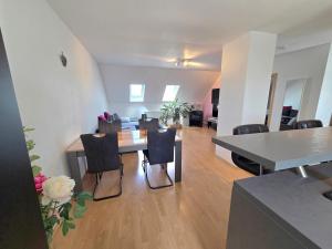 ein Esszimmer und ein Wohnzimmer mit Tisch und Stühlen in der Unterkunft Lampl Haus in Steindorf