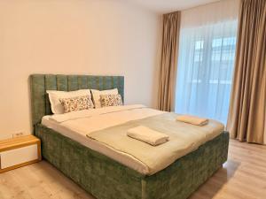 a bedroom with a large bed with two pillows on it at DOCA Apartments 10 in Otopeni