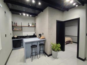 a kitchen with a sink and a counter with stools at Casa do Bem Estar Picada Café in Picada Cafe