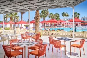 a restaurant with tables and chairs and a pool at Houda Yasmine Marina & SPA in Hammamet +20 photos