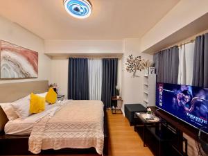 a bedroom with a bed and a flat screen tv at Corner Studio in Ermita Manila near US Embassy and SLMEC in Manila +15 photos