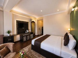 a hotel room with a large bed and a chair at Aachman Regency Shimla Mallroad in Jutogh