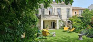 a yard with chairs and tables in front of a house at Villa Aigarden in Avignon