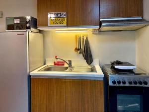 a small kitchen with a sink and a refrigerator at Corner Studio in Ermita Manila near US Embassy and SLMEC in Manila