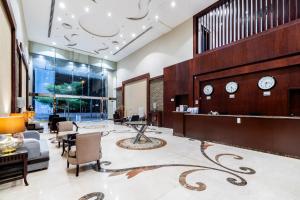a lobby with chairs and clocks on the wall at Taleen Serviced Apartments Granada- تالين غرناطة للشقق المخدومة in Riyadh