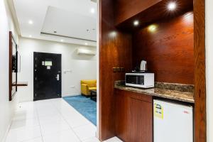 a kitchen with a counter top and a microwave at Taleen Serviced Apartments Granada- تالين غرناطة للشقق المخدومة in Riyadh