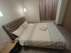 a bedroom with a large bed with a brown headboard at Воскресенская 12 Евро in Dnipro