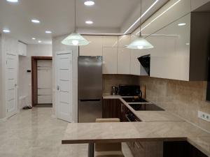 a kitchen with white cabinets and a stainless steel refrigerator at Воскресенская 12 Евро in Dnipro