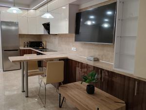 a kitchen with a large flat screen tv on the wall at Воскресенская 12 Евро in Dnipro