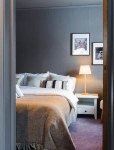 a bedroom with a bed and a table with a lamp at Bringenatten Hotell Nesbyen in Nesbyen