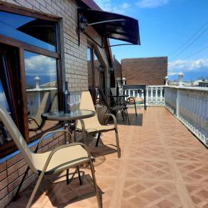 a patio with chairs and tables on a balcony at Guesthouse IMEDI in Velistsʼikhe +33 photos