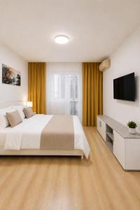 a bedroom with a large bed and a flat screen tv at Nicolle Prestige Apartment in Piteşti