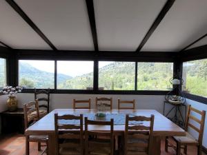 a dining room with a table and chairs and a large window at Le souffle des montagnes in Levens