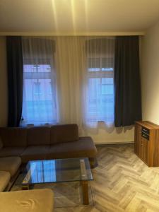 a living room with a couch and two windows at Monteur- & Gästewohnung Coswig in Coswig