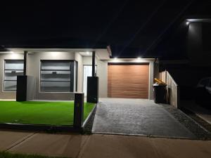 a house with a garage with a green lawn at Private Room in Rockbank in Rockbank
