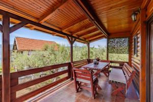 a wooden porch with a wooden table and chairs at Seaview Chalet in Herceg-Novi