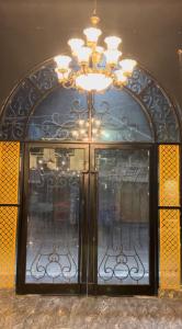 a glass door with a chandelier on top of it at Nawabz Hotel in Karnal