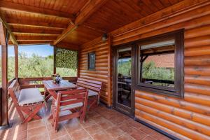 a wooden cabin with a table and chairs on a patio at Seaview Chalet in Herceg-Novi