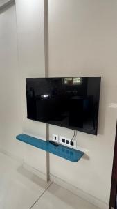 a flat screen tv on a wall with a glass shelf at G10 & 12 - Sabari Enclave Premium One bedroom Apartment in Trivandrum