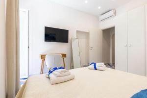 a bedroom with a white bed and a white chair at Isabel Luxury Suite in Ischia