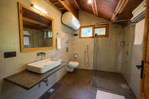 a bathroom with a sink and a toilet and a shower at Shepherd Barn Pahalgam in Pahalgām
